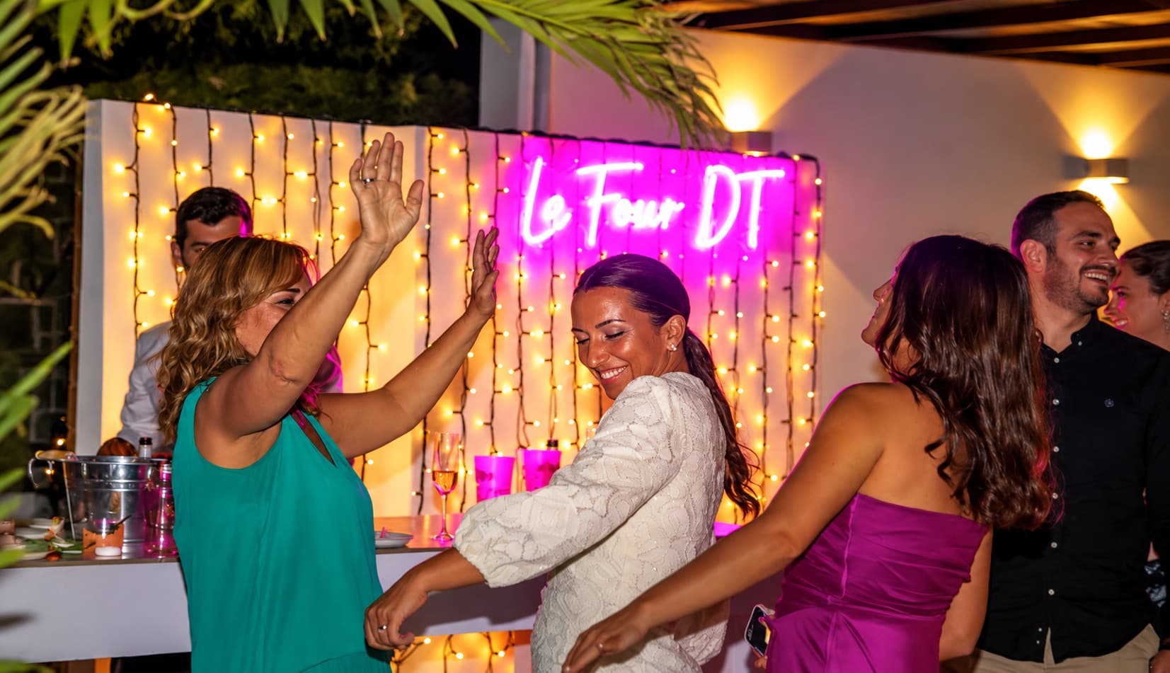 Invités dansant le soir près du bar, sous les lumières