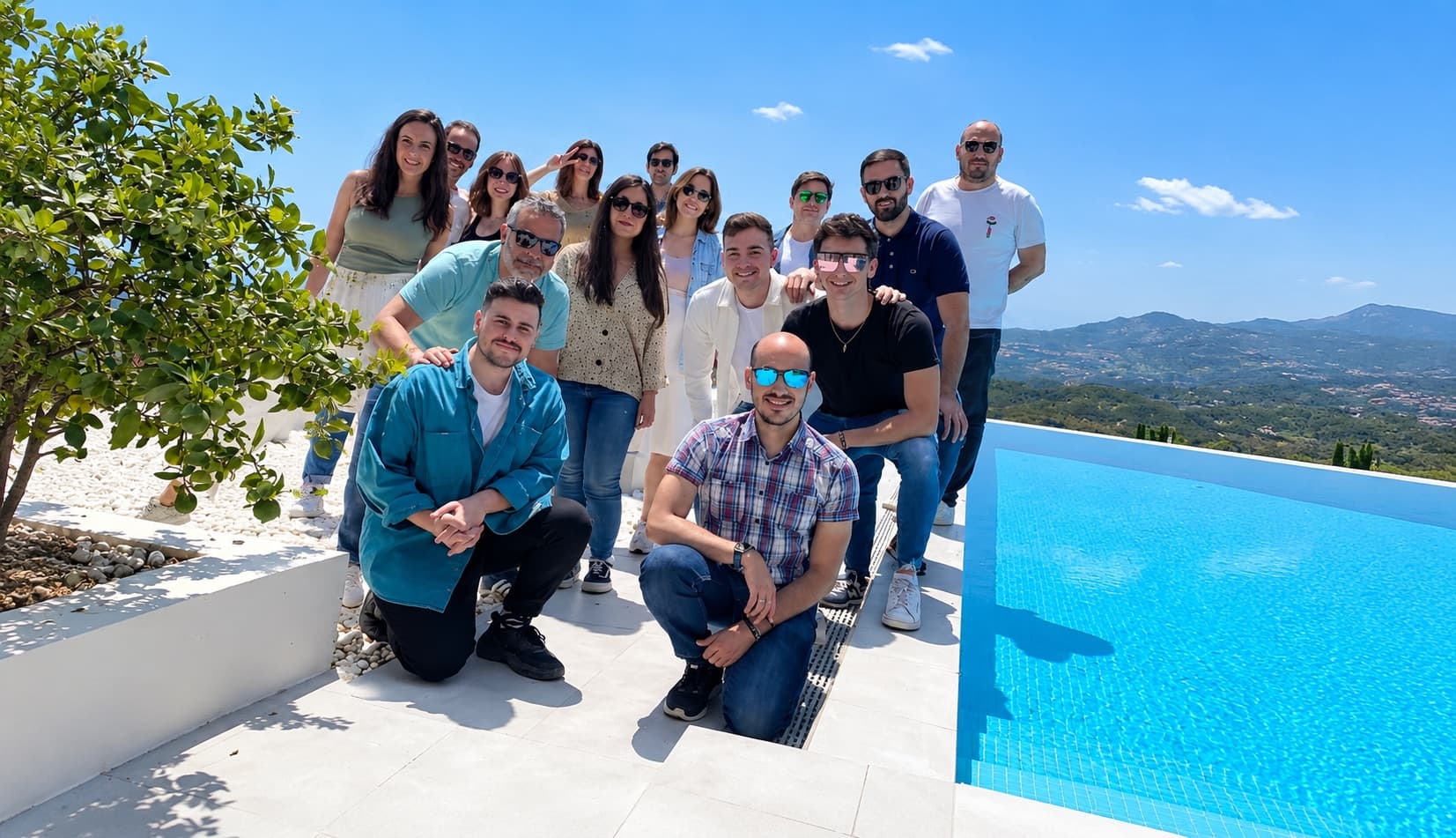 Groupe d'entreprise au bord de la piscine à débordement face à la sierra