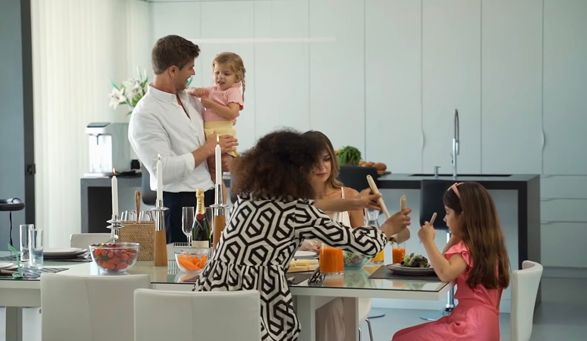 Spot Emmaljunga : famille autour de la table avec la cuisine en fond