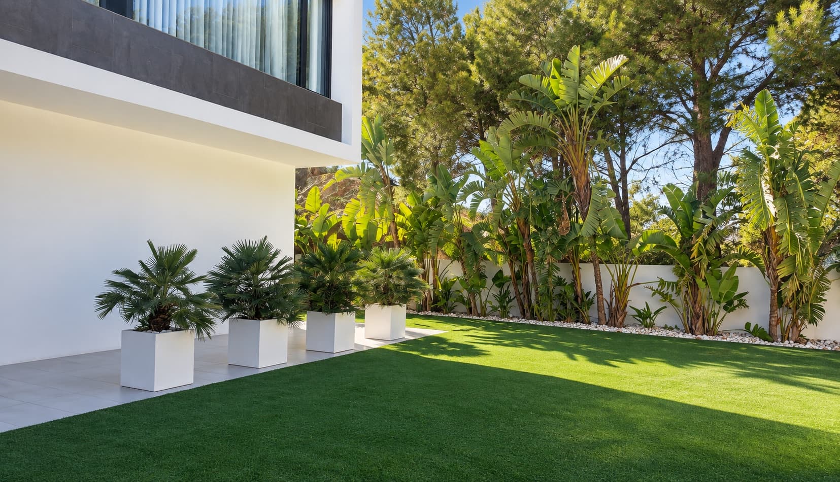 Pelouse artificielle près de la villa avec palmiers et végétation tropicale